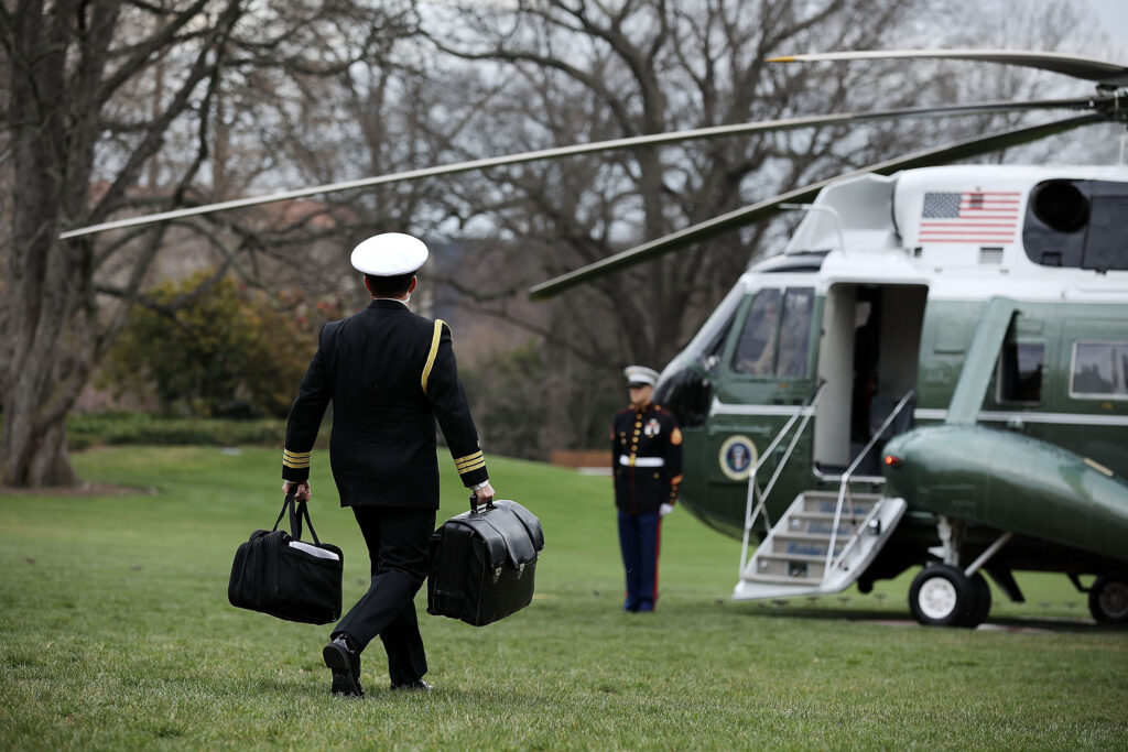 A White House military aide carries the nuclear "football" as he leaves the White House on the presidential helicopter.