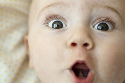 Baby looking at camera with surprised expression, portrait